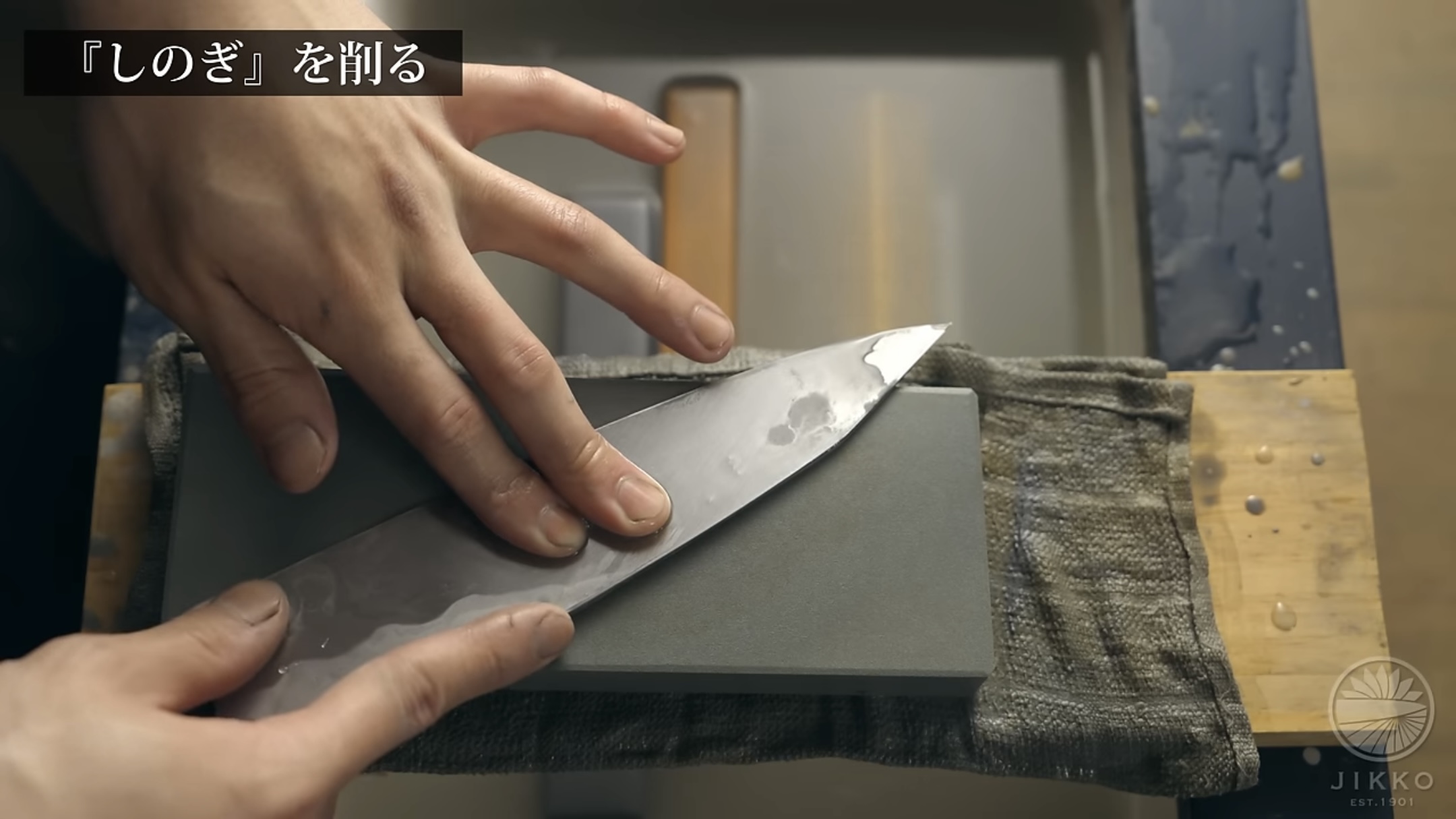 包丁を正しく持ち、砥石に包丁を当て、左手をしのぎ筋に充てる