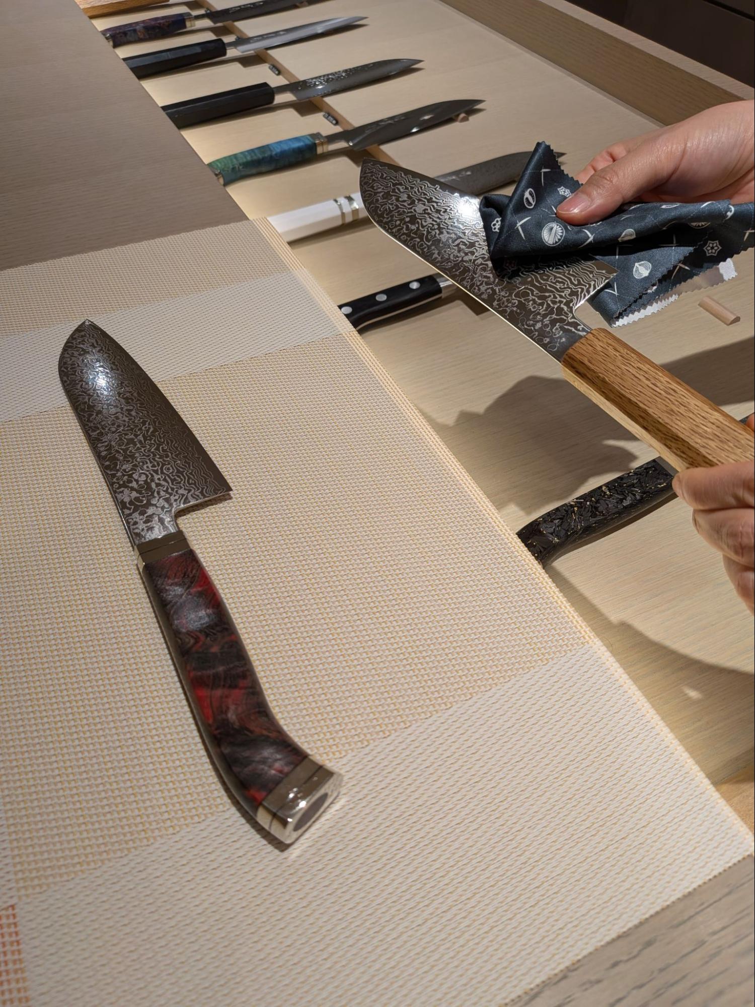 【包丁を手に取って確かめる来店客。スタッフが重さと握り心地を丁寧に案内】