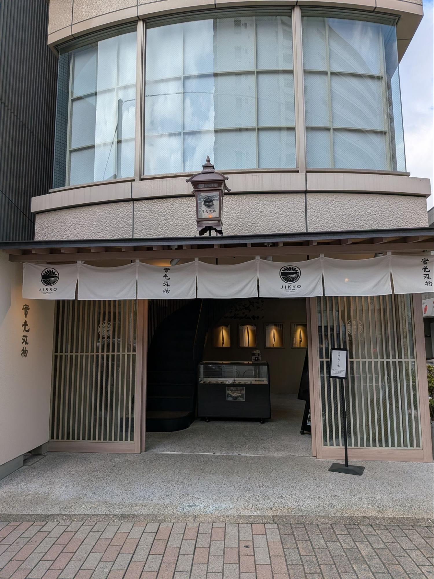 【合羽橋道具街の入口に佇む實光刃物。日差しが暖簾を優しく照らす】