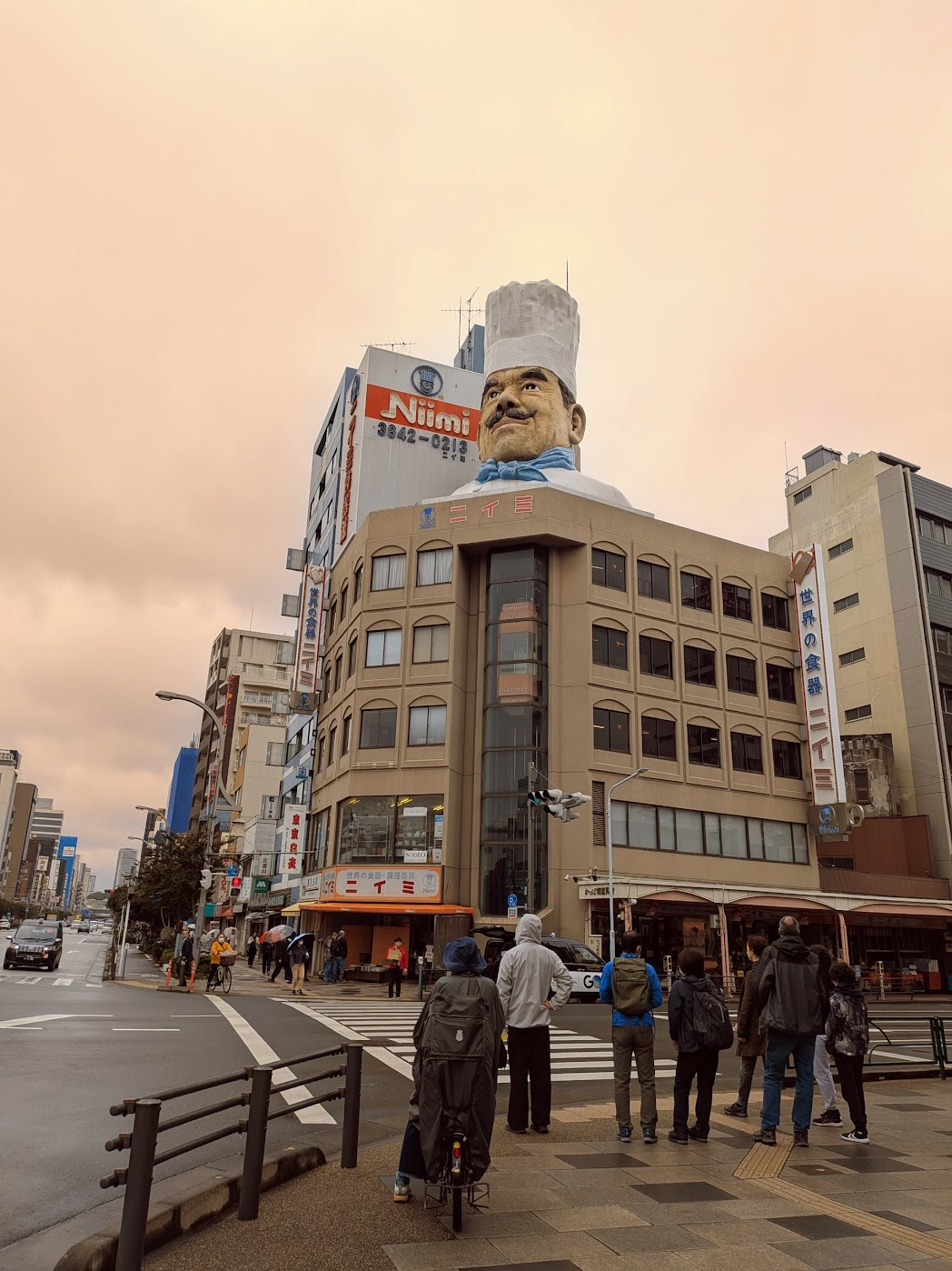 【夕暮れの合羽橋通り。包丁店の看板に明かりが灯り始める時間】
