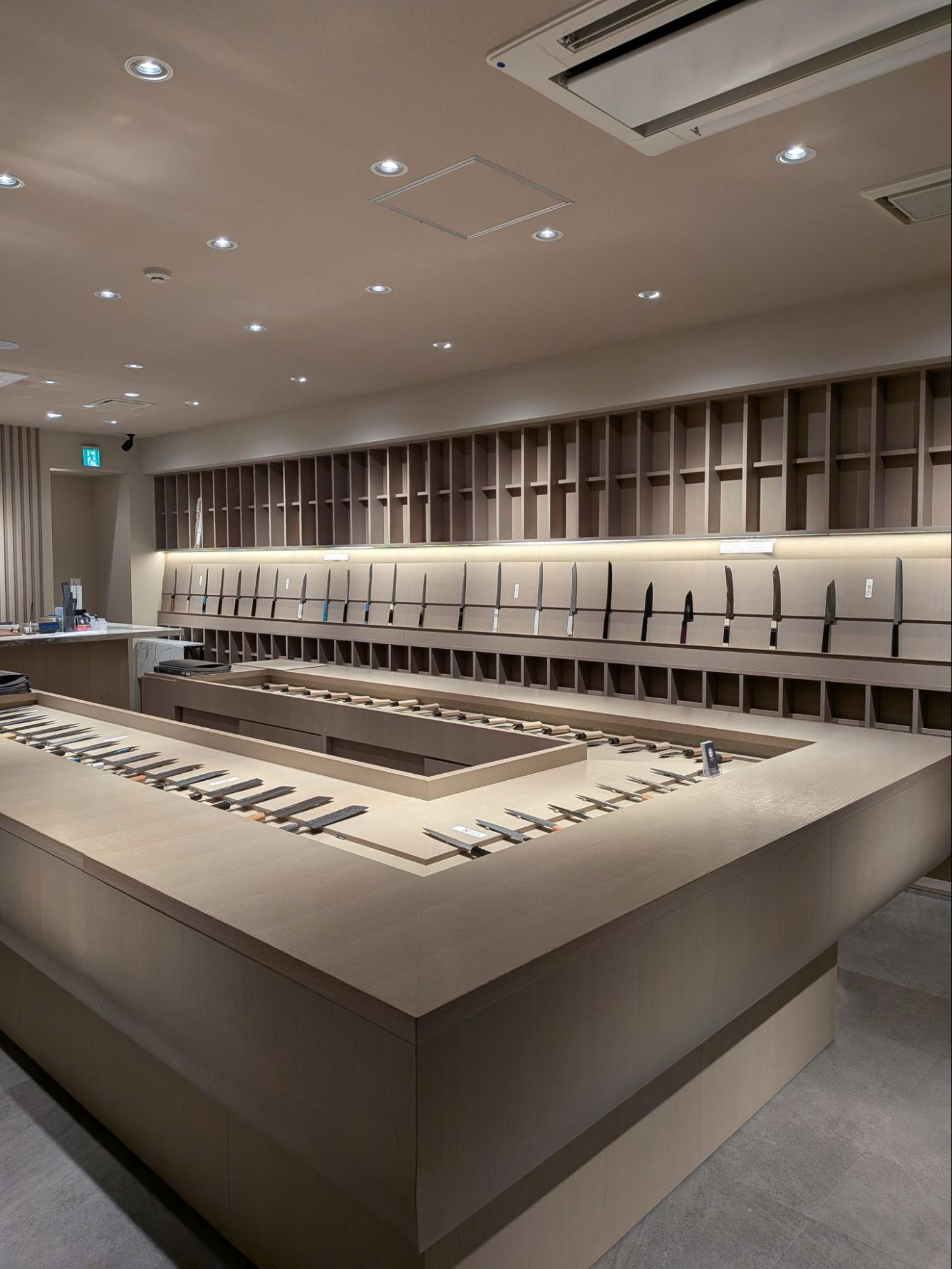 【木の温もりが漂う店内。堺職人が手掛けた包丁が整然と並ぶ】