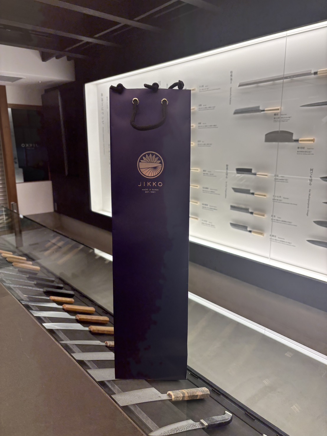 實光刃物の店舗カウンターで、包丁が入った紙袋を受け渡す前の様子