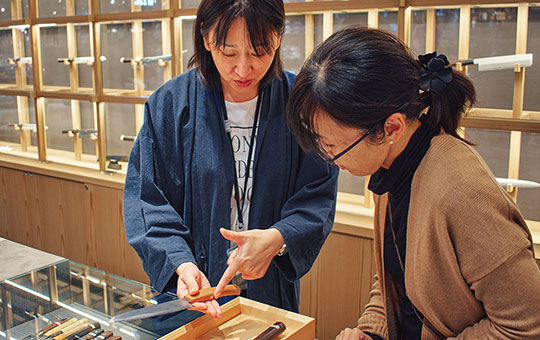 包丁選びについて、店舗スタッフが来店客に説明をしている接客の様子