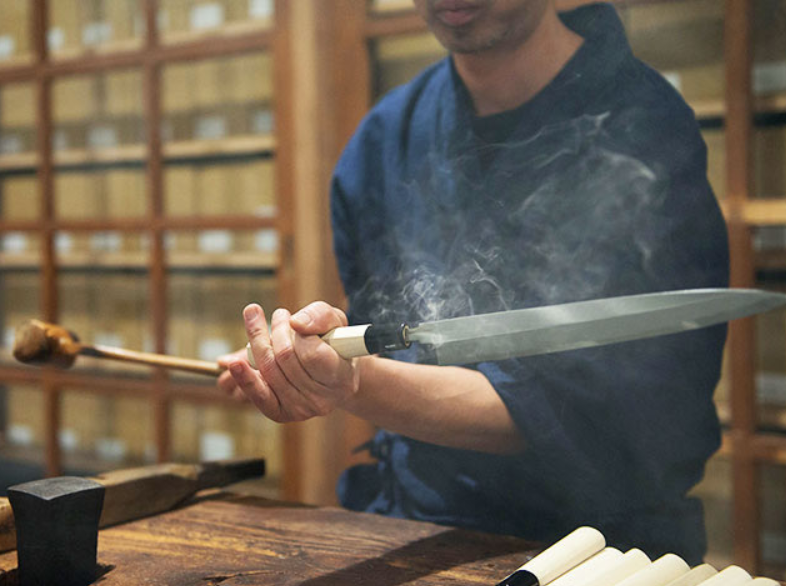 職人が熱を利用して片刃包丁に柄を取り付ける「柄付け」の工程。堺の分業制の中で、一つひとつの工程を専門の職人が担い、一本の和包丁を丁寧に仕上げていく。